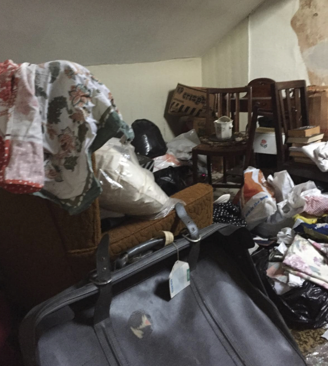 Room filled with furniture and bags before hoarding clearance
