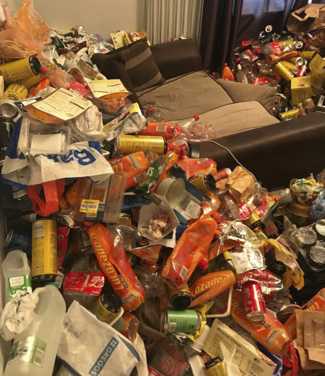 Living room buried in cans and rubbish before clearance